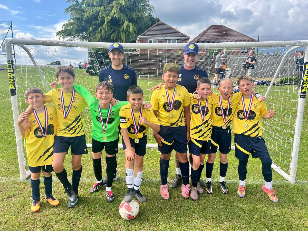The Cheetahs with their medals and coaches in front of the goal at the Chepstow tournament