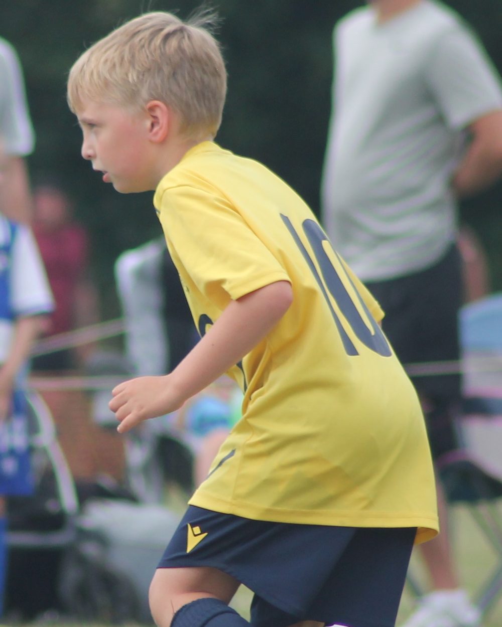 A Southside Star player in yellow shielding the ball from an opponent
