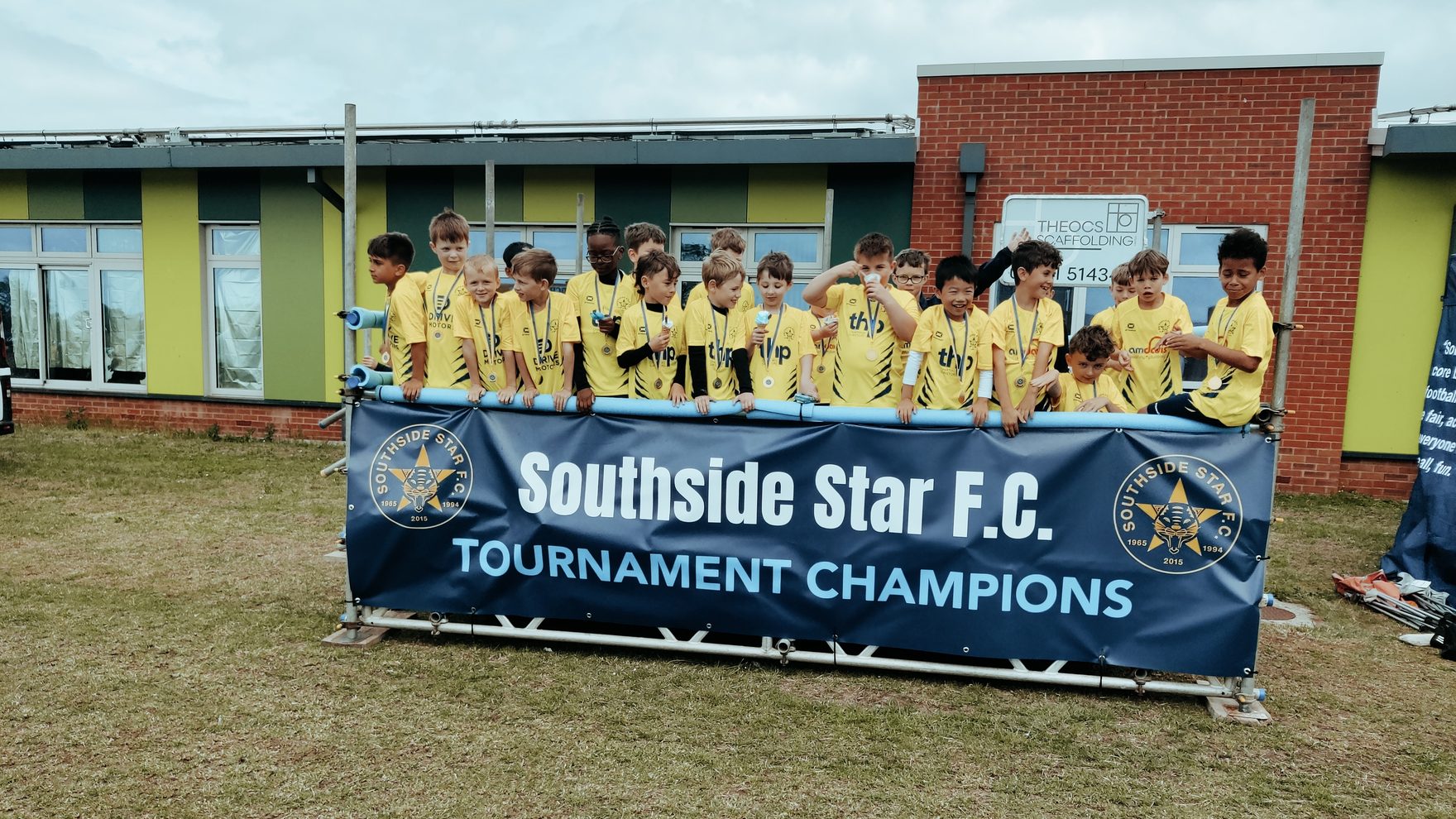 A Southside Star team with their medals behind the club's Tournament Champions banner